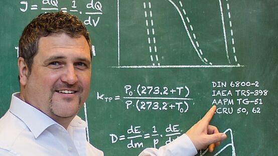 Employee of the Dosimetry School showing a board